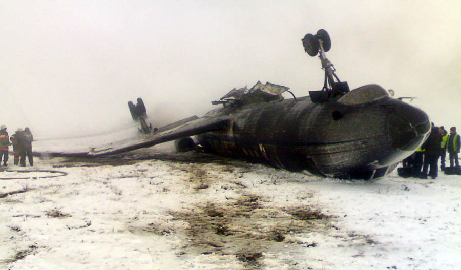 Rescuers work near an overturned Russian-made Tupolev 134 passenger jet at the airfield outside Osh on December 28, 2011. The packed TU-134 flipped over and caught fire on landing in the southern Kyrgyz city today injuring at least six people, officials and witnesses said. AFP PHOTO / AKIPRESS / POOL / STR