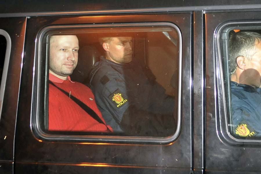 Bomb and terror suspect Anders Behring Breivik (red top) leaves the courthouse  in a police car  in Oslo on July 25, 2011, after the hearing to decide his further detention.  Breivik will be held in solitary confinement for the first four weeks, with a ban on all communication with the outside world in a bid to aid a police investigation into his acts.AFP Photo Jon-Are Berg-Jacobsen / Aftenposten