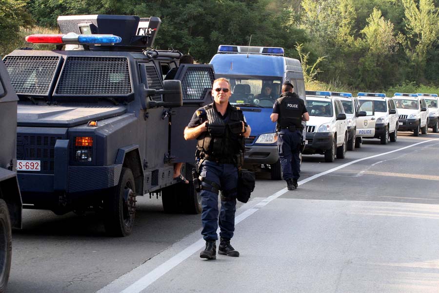 Kosovo police units wait near blockades setup by Kosovo Serbs on the Leposavic-Mitrovica road as a response to the capturing of two border crossings by Kosovo police, who seek to enforce an embargo of Serbian goods, near Leposavic, on July 26, 2011. Kosovo special police units on July 25 took control of two border crossings to enforce a new ban on imports from Serbia in a tit-for-tat move against the embargo imposed by Belgrade since 2008, when Kosovo unilaterally declared its independence. AFP PHOTO / SASA DJORDJEVIC