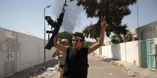 A young Libyan rebel celebrates at the Bab al-Aziziya compound in Tripoli on August 25, 2011. Hardened fighters streamed into Tripoli as Libya's rebels sought to deliver a knockout punch to Moamer Kadhafi's diehards and to flush out the elusive strongman, dead or alive. AFP PHOTO/PATRICK BAZ