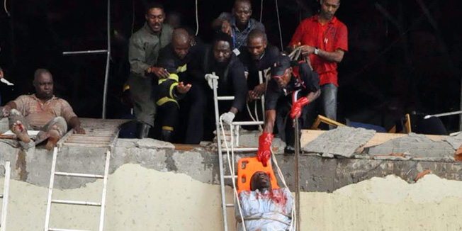 Rescue workers evacuate a wounded from the UN building of the Nigerian capital Abuja on August 26, 2011 which was rocked by a bomb that killed at least 18 people, leaving others trapped and causing heavy damage.  Some witnesses reported that the bomb exploded after a suspect rammed a car through the front gate. Parts of the first two floors of the building were blown out and rescue workers scrambled to rescue those left inside.   AFP PHOTO / HENRY CHUKWUENDO