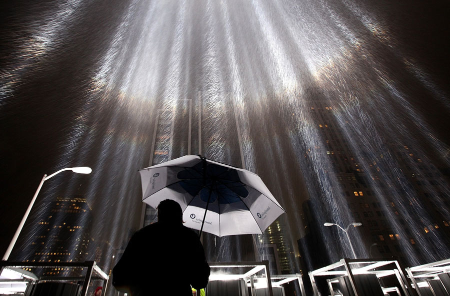 NEW YORK, NY - SEPTEMBER 07: A worker holds an umbrella while adjusting beams of the Tribute in Lights ahead of the tenth anniversary of the September 11 terrorist attacks on September 7, 2011 in New York City. The Tribute in Light is comprised of 88 7000 watt searchlights that beam into the sky near the site of the World Trade Center in remembrance of the September 11 attacks.   Justin Sullivan/Getty Images/AFP== FOR NEWSPAPERS, INTERNET, TELCOS & TELEVISION USE ONLY ==