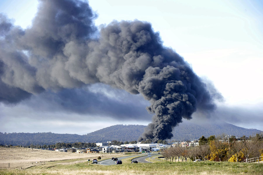 A pillar of black smoke rises from a fire at a chemical plant in the Canberra industrial area of Mitchell on September 16, 2011.  Emergency services battled a huge chemical fire in the Australian capital Canberra on on September 16 but authorities said the threat from toxic smoke plumes was diminishing.  Residents were woken by loud explosions and fireballs as flames leapt hundreds of metres into the air, reports said.  AUSTRALIA OUT NO ARCHIVES NO INTERNET RESTRICTED TO SUBSCRIPTION USE RESTRICTED TO EDITORIAL USE  AFP PHOTO / AAP / ALAN PORRITT