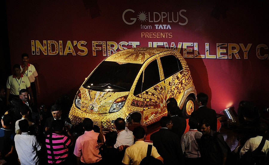 A custom Tata Motors' 'Nano' car, is seen adorned in gold, silver and gemstone trimmings during its unveiling in Mumbai on September 19, 2011. The World's first Gold jewellery car, claimed by Tata, is made from 80 kilograms of 22 karat gold, 15 kilograms of silver, and numerous gemstones. AFP PHOTO/ Punit PARANJPE