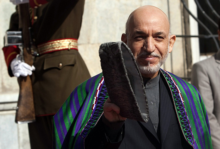 Afghan President Hamid Karzai waves as he waits to meet U.N. Secretary-General Ban Ki-moon in Kabul November 2, 2009. Ban made a surprise visit to Afghanistan on Monday as pressure grew to abandon plans for a risky run-off vote after the withdrawal of Karzai's only rival. REUTERS/Ahmad Masood(AFGHANISTAN POLITICS)