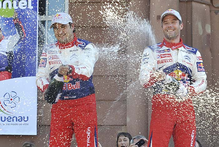 France's rally driver Sebastien Loeb (R) and his co-driver Daniel Elena celebrate on the podium at the end of the third stage of Frances new WRC round, Rallye Alsace on October 3, 2010 in Strasbourg, eastern France. Sebastien Loeb won his seventh world rally title on Sunday after triumphing in the Rally of France. AFP PHOTO / JOHANNA LEGUERRE