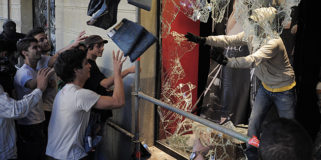 A demonstrator throws out jeans after breaking into a Levi's store in Barcelona, on Wednesday, Sept. 29, 2010. Spanish workers staged a general strike Wednesday to protest austerity measures imposed by a government struggling to slash its budget deficit and overcome recession. (AP Photo/David Ramos)