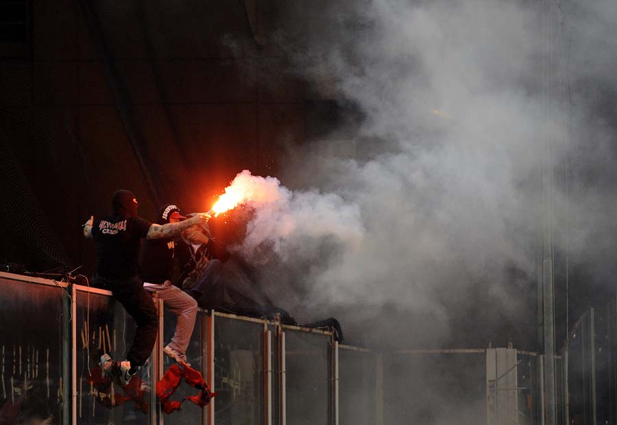 Serbian fans throw fireworks on the field before their national team's EURO2012 qualifier match Italy on October 12, 2010 in Genova.T he kick-off for Tuesday's Italy-Serbia Euro 2012 Group C qualifier was delayed due to crowd trouble. AFP PHOTO / OLIVIER MORIN