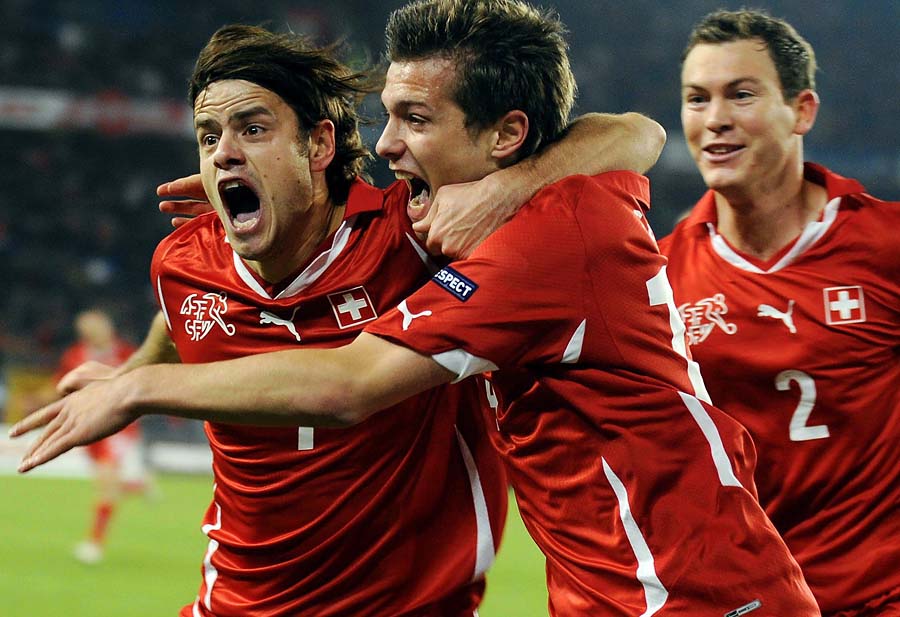 Swiss Valentin Stocker, Center, Tranquillo Barnetta, left, and Stephan Lichtsteiner, right, celebrate after the first goal for Switzerland at the St. Jakob-Park stadium in Basel, Switzerland, Tuesday, October 12, 2010. Wales plays an Euro 2012 group G qualification match against Switzerland. (AP Photo/Keystone/Walter Bieri)