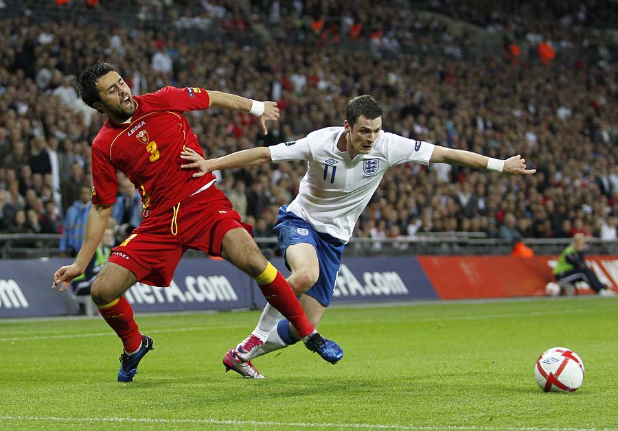 Marko Basa of Montenegro (L) vies with England's Adam Johnson during the Euro 2012 Group G qualifying football match at Wembley Stadium in London on October 12, 2010 . AFP PHOTO/IAN KINGTONNOT FOR MARKETING OR ADVERTISING USE/RESTRICTED TO EDITORIAL USE