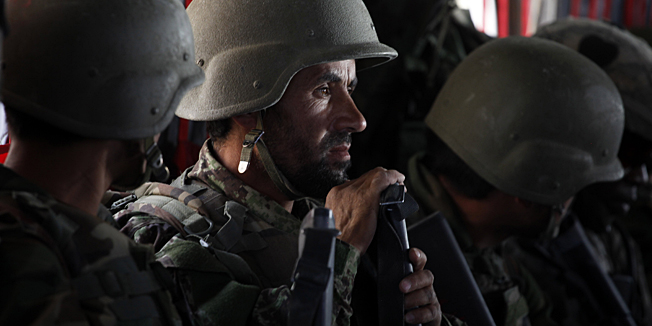 In this Sept. 11, 2010 photo, a U.S. Army helicopter from the 101st Airborne Division transports U.S. infantrymen and Afghan Army commandos from one position to another in Zhari District, southern Afghanistan. Going increasingly on the offensive in this district near Kandahar City, American commanders are hoping to clear Taliban-held areas and fighting positions in the weeks and months ahead, before President Barack Obama makes a critical assessment in December of the effectiveness of the 30,000-man surge. (AP Photo/Brennan Linsley)