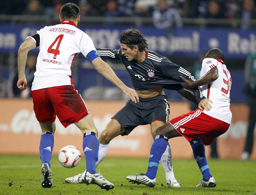 Hamburg's Heiko Westermann, left, Collin Benjamin of Namibia, right, and Munich's Mario Gomez challenge for the ball during the German first division Bundesliga soccer match between Hamburger SV and FC Bayern Munich in Hamburg, northern Germany, on Friday, Oct. 22, 2010. (AP Photo/Matthias Schrader) ** NO MOBILE USE UNTIL 2 HOURS AFTER THE MATCH, WEBSITE USERS ARE OBLIGED TO COMPLY WITH DFL-RESTRICTIONS, SEE INSTRUCTIONS FOR DETAILS **