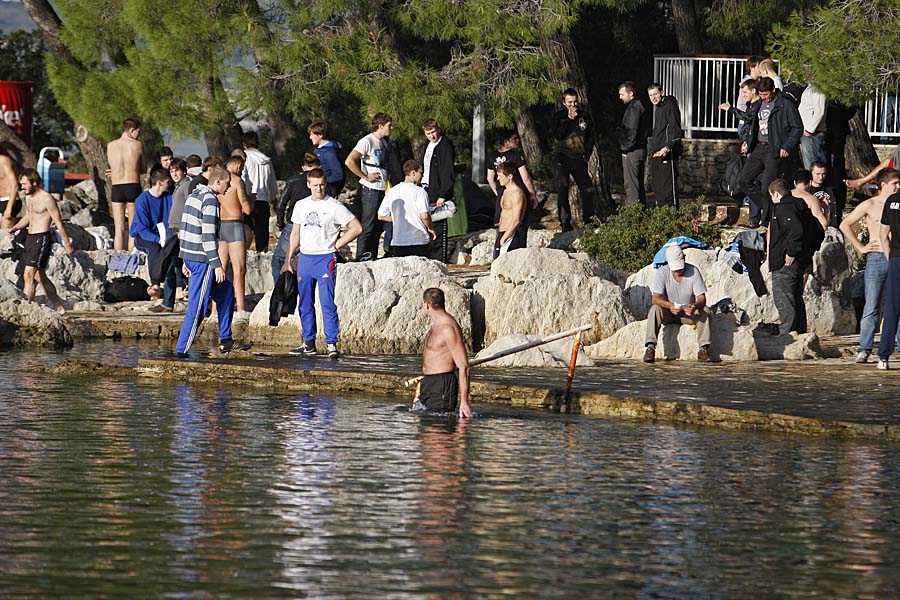 Split, 041110.Navijaci Zenita prepraceni su uz jake snage sigurnosti od splitskog aerodroma do Bena na Marjanu gdje su se kupali, a jedan navijac je priveden zbog majice sa cetnickim simbolima i pirotehnickih sredstava s kojima je uhvacen. Navijaci Zenita dosli su u Split uoci utakmice Zenit - Hajduk.Na slici: kupanje navijaca Zenita.Foto: Ante Cizmic / CROPIX