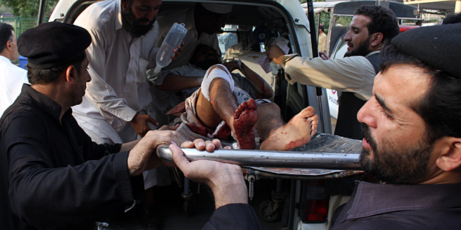 Volunteers off load an injured person from an ambulance at a local hospital in Peshawar, Pakistan on Wednesday, Oct 27, 2010. A bomb planted on a motorcycle exploded wounded six people in Pakistani tribal area of Khyber. (AP Photo/Mohammad Iqbal)