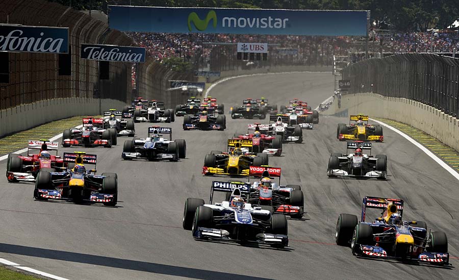 German Formula One driver Sebastian Vettel (R) powers his Red Bull to pass German Nico Hulkenberg (C) on Williams during the Brazilian Grand Prix at Interlagos racetrack in Sao Paulo on November 7, 2010.  AFP PHOTO/Mauricio LIMA