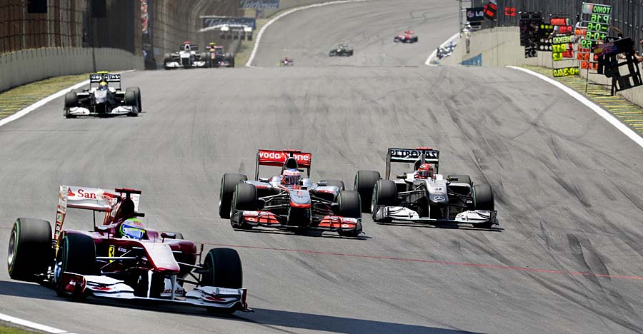 Brazilian Formula One driver Felipe Massa (L) powers his Ferrari ahead of British Jenson Button on McLaren (C) and German Michael Schumacher (R) on Mercedes during the Brazilian Grand Prix at Interlagos racetrack in Sao Paulo on November 7, 2010.  AFP PHOTO/Mauricio LIMA