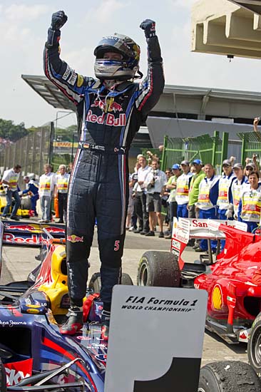 German Formula One driver Sebastian Vettel celebrates his victory in the Brazilian Grand Prix at Interlagos racetrack in Sao Paulo on November 7, 2010. Sebastian Vettel led a Red Bull one-two at the Brazilian Grand Prix on Sunday finishing ahead of team-mate Mark Webber. World Championship leader Fernando Alonso in a Ferrari was third and he will start next week's final race in Abu Dhabi eight points ahead of Webber and 15 points ahead of Vettel. The result saw Red Bull crowned constructors champions for the first time.  AFP PHOTO/ANTONIO SCORZA