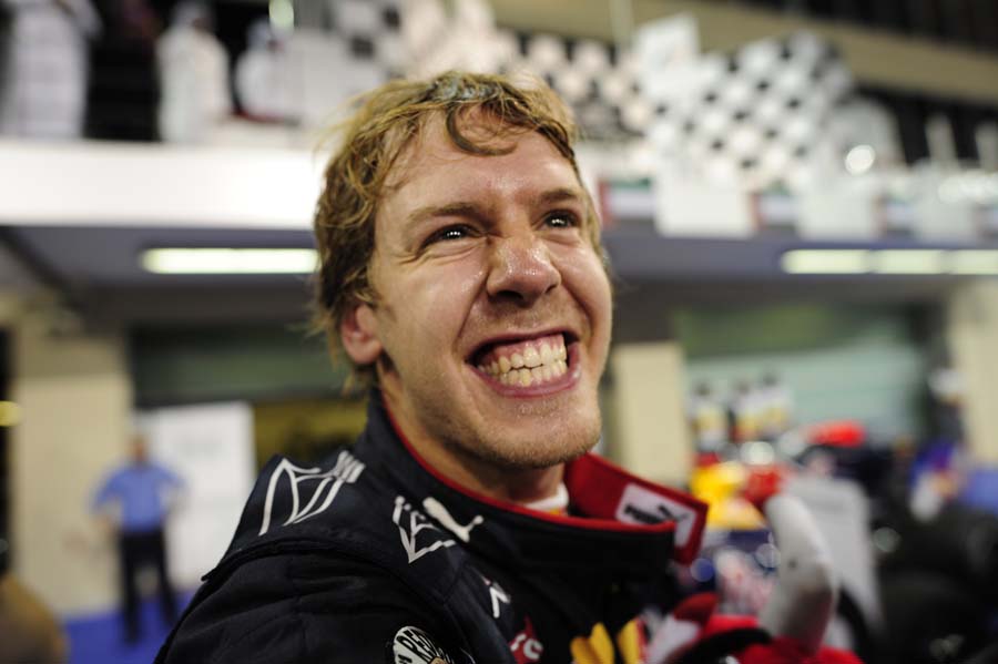 Red Bull's German driver Sebastian Vettel celebrates in the park ferme after winning at the Yas Marina circuit on November 14, 2010 in Abu Dhabi, after the Abu Dhabi Formula One Grand Prix.   Red Bull's German driver Sebastian Vettel won the World championship and the race ahead of McLaren Mercedes' British driver Lewis Hamilton and McLaren Mercedes' British driver Jenson Button.       AFP PHOTO / FRED DUFOUR