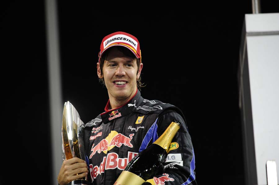 Red Bull's German driver Sebastian Vettel holds his trophy on the podium of the Yas Marina circuit on November 14, 2010 in Abu Dhabi, after the Abu Dhabi Formula One Grand Prix. Vettel won the race and the 2010 drivers' world championship.                 AFP PHOTO / KARIM SAHIB