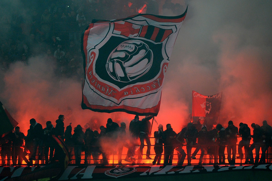 AC Milan's supporters wave flags and alight flares during their team's Italian Serie A football match against Inter Milan on November 14, 2010 in San Siro stadium in Milan. AFP PHOTO / OLIVIER MORIN