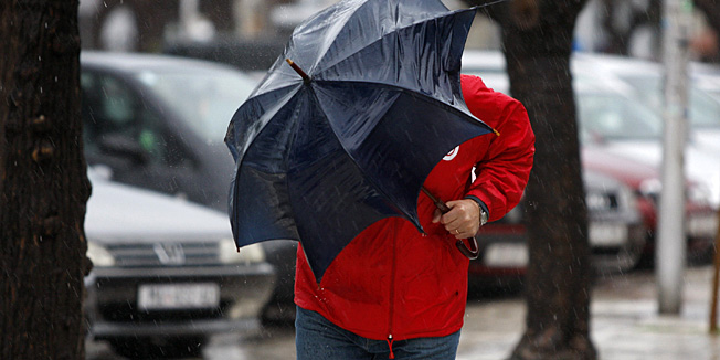 Makarska, 080110.Jugo praceno kisom koje na makarskom podrucju puse brzinom od 60-ak km/h s udarima do 90km/h  na primorju nije uzrok vecih problema ali su valovi koje dize u Brackom kanalu uzrok prekidu trajektnih linija Makarska-Sumartin(o. Brac) i Drvenik-Sucuraj(o. Hvar). Na slici: covjek s kisobranom bori se s jakim vjetrom.Foto: Ivo Ravlic / CROPIX