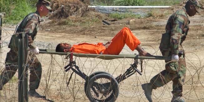 FILE - In this Feb. 2, 2002 file photo, a suspected al-Qaida or Taliban detainee from Afghanistan is carried on a stretcher before being interrogated by military officials at the detention facility Camp X-Ray on Guantanamo Bay U.S. Naval Base in Cuba. (AP Photo/Lynne Sladky, File) PHOTO PACKAGE FOR USE WITH AFGHANISTAN ANNIVERSARY STORIES