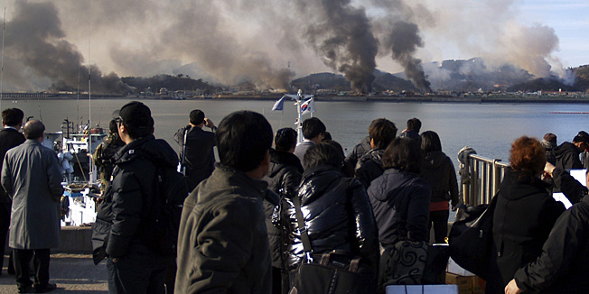 South Koreans watch smoke raising from South Korea's Yeonpyeong island near the border against North Korea Tuesday, Nov. 23, 2010. North Korea fired artillery barrages onto the South Korean island near their disputed border Tuesday, setting buildings alight and prompting South Korea to return fire and scramble fighter jets. (AP Photo/Yonhap) KOREA OUT