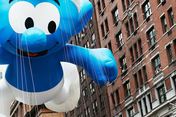 NEW YORK - NOVEMBER 25: The Smurf float passes by people watching from apartments and offices on Seventh Avenue, heading south to Times Square during the Macy's Thanksgiving Day parade November 25, 2010 in New York City. The 84th annual celebration featured approximately 8,000 participants including more 1,600 cheerleaders and dancers, twelve marching bands, and an assortment of celebrities in addition to 15 giant character balloons.   Chris Hondros/Getty Images/AFP== FOR NEWSPAPERS, INTERNET, TELCOS & TELEVISION USE ONLY ==