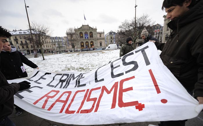 Demonstrator hold a banner reading 'Crime is racism' during a demonstration against a referendum to automatically expel foreign residents from Switzerland if convicted of certain crimes on November 28, 2010 in Geneva. Switzerland endorsed a far-right push to automatically expel foreign residents convicted of certain crimes, poll results from 25 out of 26 cantons show. With only results from the small canton of Solothurn to come, the initiative put forward by the Swiss People's Party was approved by 52.7 percent of voters, while 47.3 percent were against. The initiative, which was been criticised by human rights campaigners, came exactly a year after the country shocked the world by approving a ban on the construction of minarets.  AFP PHOTO / FABRICE COFFRINI