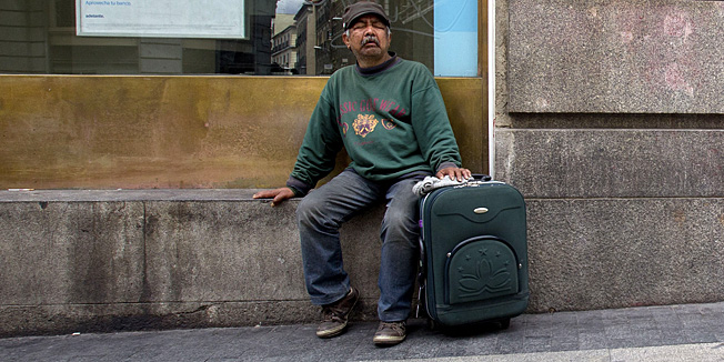 A man rests outside a bank advertising their bank rates and pension plans in Madrid  Sunday June 10, 2012. Spain's grinding financial misery will get worse this year despite the country's request for a European financial lifeline of up to a euro100 billion euros ($125 billion) to save its banks, Prime Minister Mariano Rajoy said Sunday, a big blow to a nation that took pride as the continent's economic superstar just a few years ago only to see it become the hot spot in the eurozone debt crisis. A day after conceding Spain needed outside help after months of denying it would seek assistance, Rajoy said more Spaniards will lose their jobs in a country where one out of every four are unemployed as the country becomes the fourth and largest of the 17 countries that use Europe's common currency to request a bailout. (AP Photo/Paul White)