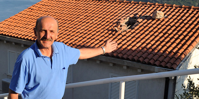 Dubrovnik, 160612.Danas popodne se s obronka Srdja otkinula stijena i, udarivsi o zastitnu ogradu na magistrali, odbila se na krov kuce obitelji Krecak.Na slici: Ivo Krecak pokazuje stijenu i ostecenje.Foto: Zeljko Tutnjevic / DUBROVACKI VJESNIK / CROPIX