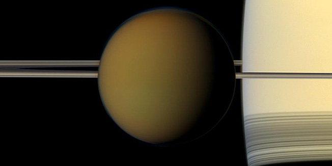 This undated true color image by the Cassini spacecraft released by NASA shows Saturn's largest moon, Titan, passing in front of the planet and its rings. A new study released Thursday, June 28, 2012 suggests there may be an ocean below Titan's frigid surface. (AP Photo/NASA)