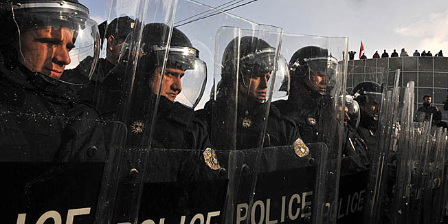 Kosovo police in riot gear face supporters of Self-Determination (VETVENDOSJE!) during clashes in the northern Kosovo town of Podujevo on Saturday, Jan. 14, 2012. Police in Kosovo fired tear gas and used batons and a water cannon to disperse hundreds of protesters trying to enforce a trade ban on Serbian goods. ( AP Photo / Visar Kryeziu )