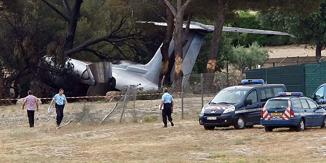 Police Officers walk near the plane that crashed on landing at Le Castellet airport, near Toulon, southern France, Friday, July, 13, 2012. Three US citizen died in the accident. (AP Photo/Claude Paris)