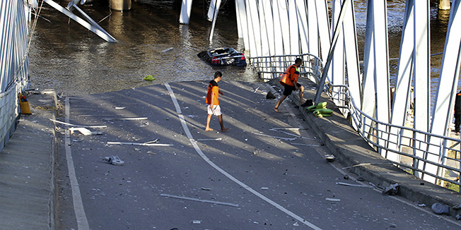 Rescuers inspect the damage of Kutai Kartanegara bridge after it collapsed, in Tenggarong, east Kalimantan, Indonesia, Saturday, Nov. 26, 2011. The busy bridge collapsed Saturday in central Indonesia, killing at least three people and injuring 17 others as a bus, cars and motorcycles crashed into the river below, police and witnesses said. (AP Photo)