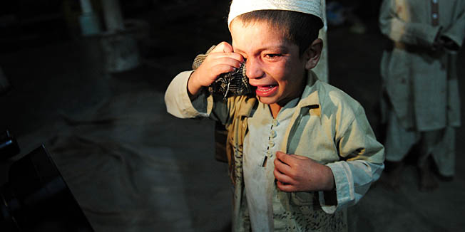 A young student cries after being rescued following a police raid on Madrassa Zakarya in Karachi late on December 12, 2011. Pakistani police rescued 45 students found chained in the basement during a raid late December 12 on an Islamic seminary in the southern port city of Karachi, police said. According to government records, there are at least 15,148 seminaries in Pakistan with more than two million students -- around five percent of the 34 million children in formal education. AFP PHOTO / ASIF HASSAN