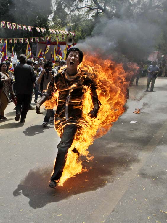 ALTERNATE CROP OF DEL108 - A Tibetan man screams as he runs engulfed in flames after self-immolating at a protest in New Delhi, India, ahead of Chinese President Hu Jintao's visit to the country Monday, March 26, 2012. The Tibetan activist lit himself on fire at the gathering and was rushed to hospital with unknown injuries, reports said. (AP Photo/Manish Swarup)