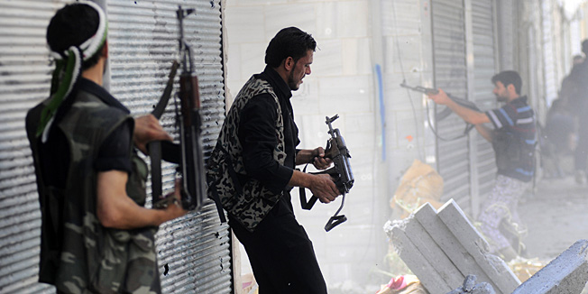 In this Wednesday, Aug. 1, 2012 photo, a Free Syrian Army soldier fires his weapon during clashes with Syrian government forces in Saladin neighborhood, in Aleppo, Syria. (AP Photo/Alberto Prieto)