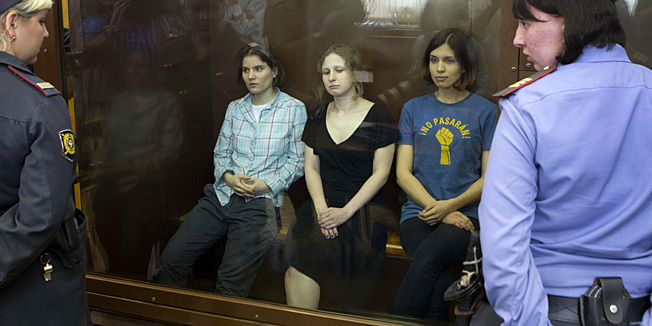 Feminist punk group Pussy Riot members, Nadezhda Tolokonnikova, right, Maria Alekhina, center, and Yekaterina Samutsevich sit in a glass cage at a court room in Moscow, Russia, Friday, Aug. 17, 2012. Security is tight around a Moscow courthouse where three members of the feminist punk band Pussy Riot are to hear the verdict Friday in a trial that could send them to prison for seven years. (AP Photo/Misha Japaridze)