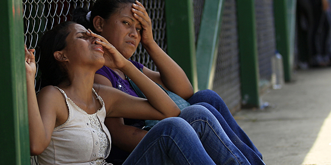 Relatives of a inmate cry while waiting for information outside Yare I prison in San Francisco de Yare, Venezuela,  Monday, Aug. 20, 2012. More than 20 people were killed in a prison riot last Sunday as two groups of inmates waged a gun-battle inside the penitentiary, Venezuelan officials said Monday. (AP Photo/Fernando Llano)