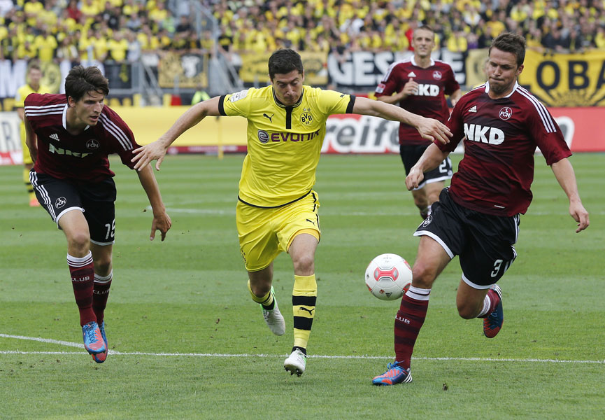 Nuremberg's Per Nilsson, right, and Timm Klose, left, and Dortmund's Robert Lewandowski challenge for the ball during the German first division Bundesliga soccer match between 1. FC Nuremberg and Borussia Dortmund in Nuremberg, Germany, Saturday, Sept.1, 2012. (AP Photo/Michael Probst) - NO MOBILE USE UNTIL 2 HOURS AFTER THE MATCH, WEBSITE USERS ARE OBLIGED TO COMPLY WITH DFL-RESTRICTIONS, SEE INSTRUCTIONS FOR DETAILS -