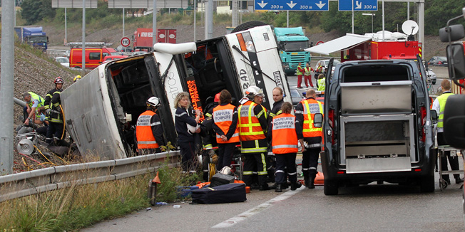 Rescue workers gather at the crash site after a Polish double-decker bus toppled over on a highway in the northeast of France, near Mulhouse, killing at least two people, Tuesday, Sept. 11, 2012. The bus was carrying 65 passengers and three crew from Poland to southern France when it toppled over early Tuesday on the A36 highway near Mulhouse. (AP Photo) FRANCE OUT