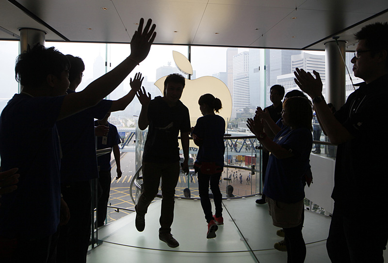 Customers cheer with staff members of Apple Inc. as the Apple store in Hong Kong started selling iPhone 5 Friday, Sept. 21, 2012.  Apple's Asian fans jammed the tech juggernaut's shops in Australia, Hong Kong, Japan and Singapore to pick up the latest version of its iPhone. (AP Photo/Kin Cheung)