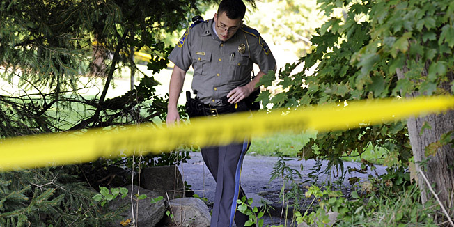 State Trooper Matt Losh emerges from the backyard of a home in New Fairfield, Conn., where a fatal shooting took place, Thursday, Sept. 27, 2012. Police say Jeffrey Giuliano shot a masked teenager in self-defense during what appeared to be an attempted burglary early Thursday morning, then discovered that he had killed his son, Tyler. (AP Photo/The News-Times, Carol Kaliff)  MANDATORY CREDIT