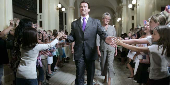 FILE - In this Sept. 8, 2008 file photo, Gov. Arnold Schwarzenegger is greeted by children as he walks to a ceremony to honor several Olympic athletes from California, at the Capitol in Sacramento, Calif. While he drew crowds wherever he went, Schwarzenegger will be leaving office in January 2011 with a mixed record, winning praise for his precedent-setting environmental activism and criticism for his failure to tame the fiscal mess as promised when voters elected Schwarzenegger to replace Gov. Gray Davis in the historic 2003 recall election. (AP Photo/Rich Pedroncelli, File)