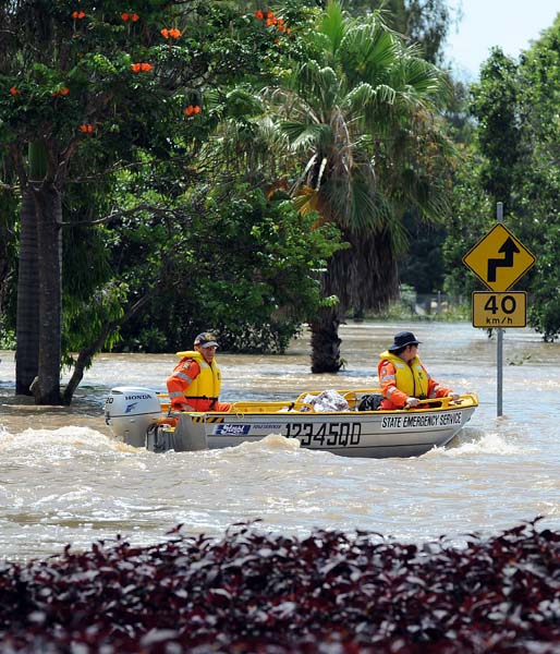 Emergency personnel patrol the flooded Bruce Highway by boat after the Fitzroy River broke its banks and inundated much of Rockhampton on January 4, 2011. Up to 200,000 people are estimated to have been hit by the floods which have left entire towns under water and cut off many more over an area the size of France and Germany combined, wreaking untold billions in damage to crops and the nation's key mining industry.  AFP PHOTO / Torsten BLACKWOOD