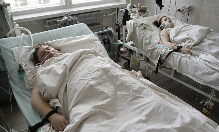 Women are taken care of in an intensive care unit at a hospital in Ternopil in western Ukraine, October 31, 2009. Ukraine closed schools and banned public meetings including election rallies and restricted travel on Friday for a three-week period after confirming its first death from H1N1 flu. REUTERS/Viktor Gurniak (UKRAINE POLITICS HEALTH)
