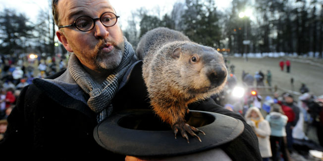 PUNXSUTAWNEY, PA - FEBRUARY 2: Groundhog handler Ben Hughes watches Punxsutawney Phil after he did not see his shadow predicting an early spring during the 125th annual Groundhog Day festivities on February 2, 2011 in Punxsutawney, Pennsylvania. Groundhog Day is a popular tradition in the United States and Canada. A smaller than usual crowd this year of less than 15,000 people spent a night of revelry awaiting the sunrise and the groundhog's exit from his winter den. If Punxsutawney Phil sees his shadow he regards it as an omen of six more weeks of bad weather and returns to his den. Early spring arrives if he does not see his shadow causing Phil to remain above ground.   Jeff Swensen/Getty Images/AFP== FOR NEWSPAPERS, INTERNET, TELCOS & TELEVISION USE ONLY ==