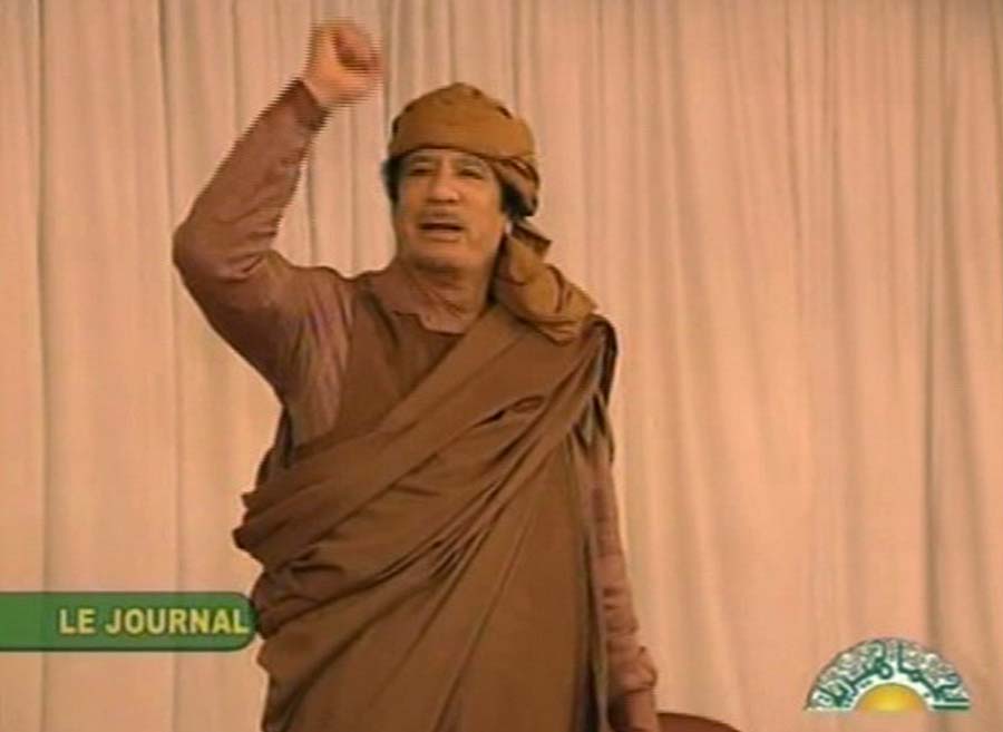 This video image broadcast on Libyan state television Sunday Feb. 20, 2011 shows longtime Libyan leader Moammar Gadhafi appearing in Tripoli in the evening Saturday Feb. 19, 2011. Women and children were seen among his supporters, many of whom chanted and held pictures in support of their leader. Libyan forces fired machine-guns at mourners marching in a funeral for anti-government protesters in the eastern city of Benghazi Sunday, a day after commandos and foreign mercenaries loyal to longtime leader Moammar Gadhafi pummeled demonstrators with assault rifles and other heavy weaponry.  (AP Photo/Libyan state television)   TV OUT LIBYA OUT