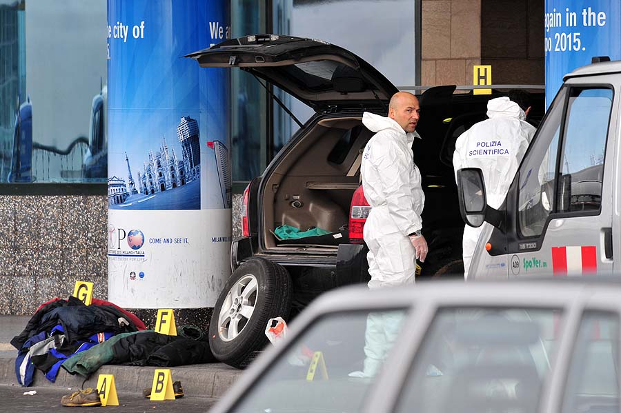 Forensic policemen search in a car in front of a terminal of Malpensa airport near Milan after a man smashed it into the terminal and was shot by a police officer after trying to stab him on February 21, 2011. Flights out of Milan's Malpensa airport were suspended Monday and a terminal building evacuated after a Tunisian man who was in a car with his wife and three children tried to smash into the terminal in a moment of madness.  AFP PHOTO / GIUSEPPE CACACE